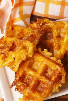 some waffles on a white plate with a yellow and orange checkered table cloth