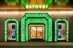 the entrance to a luxury store with green lights on it's front door and windows