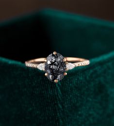 a diamond ring sitting on top of a velvet box