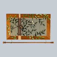 a wooden frame with green leaves on it and two bamboo poles in front of it