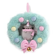 a stuffed animal with a pink bow around it's neck in front of a wreath