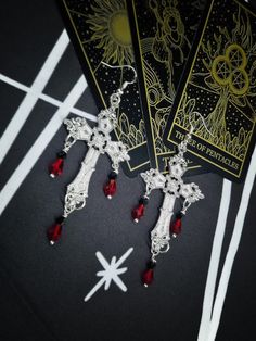 Our beautiful handmade Dark Lady Vampire  Gothic Cross Dangle Earrings are statement earrings which are sure to get you  noticed  they  feature a beautiful silver toned cross design with elegant red gem drops  a choice of earring style to customize to your requirement 🩸 All our Jewelry comes nicely packaged in a organza gift bag with cute stickers  All parcels come packaged in an fsc approved parcel and all packaging is fully recyclable ♻ 𝙋𝙧𝙤𝙙𝙪𝙘𝙩 𝙄𝙣𝙛𝙤𝙢𝙖𝙩𝙞𝙤𝙣 🔸Huggy Hoops Or 925 Lady Vampire, Vampire Earrings, Vampire Gothic, 11th Wedding Anniversary, Jewelry Halloween, Gothic Cross, Gothic Crosses, Witch Jewelry, Elegant Red