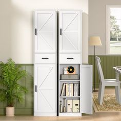 a white bookcase with doors is in the corner of a room next to a table and chair