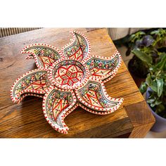 an intricately decorated wooden box on a table with potted plants in the background