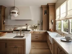 a kitchen filled with lots of wooden cabinets and counter top space next to a window