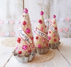 three cupcakes decorated with pink and red decorations