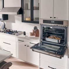 a kitchen with an oven, stove and counter tops in white cabinets is seen here