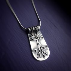 Silver Tree of Life Necklace on purple background. Necklace has roots and branches that go over the bail. Pendants with meaning handmade Vermont. Unique Sterling Silver Tree Of Life Necklace, Spiritual Tree Of Life Sterling Silver Necklace, Symbolic Tree Of Life Sterling Silver Jewelry, Symbolic Sterling Silver Tree Of Life Jewelry, Spiritual Sterling Silver Jewelry With Tree Of Life, Sterling Silver Tree Of Life Nature-inspired Jewelry, Inner Wisdom, Silver Tree, Tree Of Life Necklace