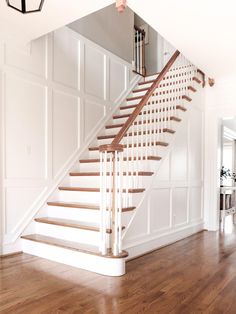 a white staircase with wooden handrails in a house