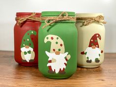 three mason jars with gnomes painted on them