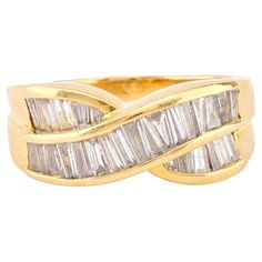 a yellow gold ring with three baguettes and two rows of diamonds on the band