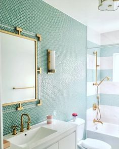 a white toilet sitting next to a bath tub under a bathroom mirror above a sink