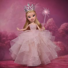 a barbie doll wearing a tiara and holding a sparkle wand in her hand, on a pink background