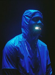 a man wearing a blue jacket with a light on his face