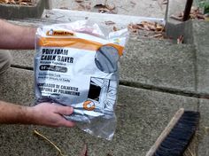 a man is sitting on the steps holding a bag of cement and cleaning it with a brush