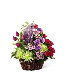 a basket filled with lots of different colored flowers