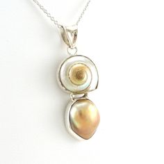 Malabar shell and bronze baroque pearl is handmade with sterling silver in Bali, Indonesia. A nice 1/4 inch sterling silver bezel setting holds the pearl shell combination that hangs from an 18 inch rhodium plated sterling silver cable chain. Pendant is 1 1/2 inches long and 1/2 inch wide. Necklace comes in a jewelry gift box. Style Number: 6689 Metal: 925 Sterling Silver Gemstone: Genuine Malabar Shell and Nautilus Shell Dimensions: 1 1/2 inches long and 1/2 inch wide Handmade in Bali, Indonesi 2024 Wardrobe, Nautilus Shell, Baroque Pearl Necklace, Pearl Shell, The Pearl, Jewelry Inspo, Chain Pendant, Baroque Pearls, Jewelry Gift Box