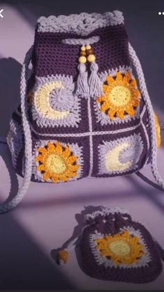 a crocheted purse with sunflowers on it and a matching bag to the side