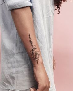 a woman's arm with a flower tattoo on the left side of her arm