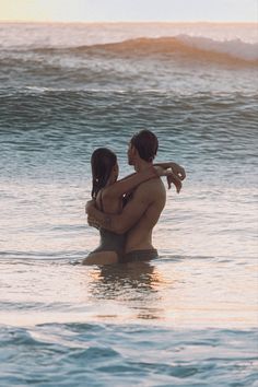 two people are in the water hugging each other