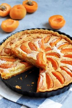 there is a pie on the table with oranges around it