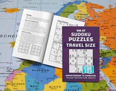 the sudoku puzzles travel size book is open on a world map and it's contents are visible