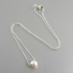 Wear this lovely necklace to the office or an evening out. Made with a single white 9mm freshwater pearl suspended from sterling silver chain with a sterling silver clasp. The pearl size for this necklace is 9mm. There is a bead size chart in the last photo so you can see what 9mm will look like. The necklace is available in four necklace lengths. Please choose the length you need from the drop-down menu. The necklace will arrive in an attractive gift box. Minimalist Sterling Silver Pearl Necklace For Formal Occasions, Sterling Silver Charm Necklace With Pearl Chain For Gift, Classic Akoya Pearl Necklace For Gift, Classic Charm Necklace With Pearl Pendant, Pearl White Sterling Silver Necklace With Pearl Charm, White Gold Sterling Silver Single Strand Pearl Necklace, Classic Charm Necklace With Round Pearl Pendant, White Gold Single Strand Pearl Necklace In Sterling Silver, Classic White Pearl Charm Necklaces