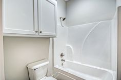 a white toilet sitting next to a bath tub