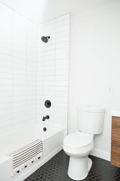 a white toilet sitting next to a bath tub