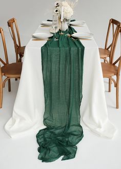 the table is set with white and green linens