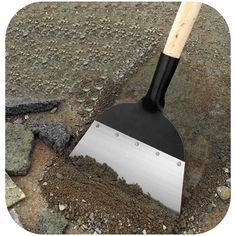 a shovel is stuck in the ground next to some rocks and gravel on which there are stones