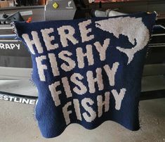 there is a knitted pillow that says here fishy, fishy and fly