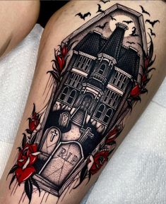 a woman's thigh with a house and flowers tattoo on her leg, in black and white