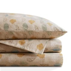 two pillows stacked on top of each other with pineapples printed on the covers