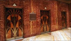 an empty room with wooden walls and art deco style doors on the wall, in front of a marble floor