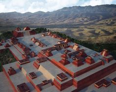 an aerial view of a building with mountains in the background