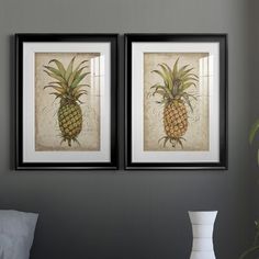 two framed pineapples are hanging on the wall