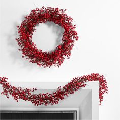 a red wreath is hanging on the wall next to a fire place with a fireplace