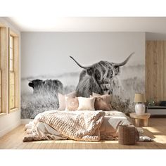 a bedroom with a large wall mural depicting two long horn cows in the field,