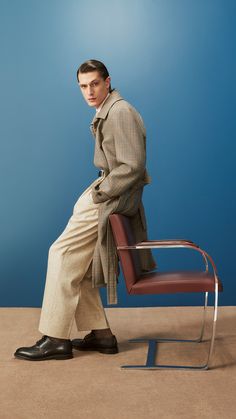 a man sitting on top of a chair next to a blue wall