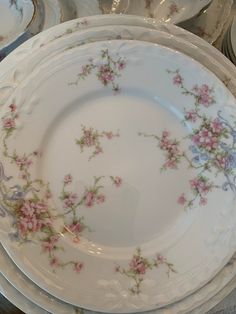 a stack of white plates with pink flowers on them