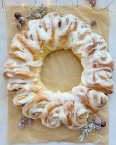 a bundt cake with white icing on a piece of wax paper next to christmas lights