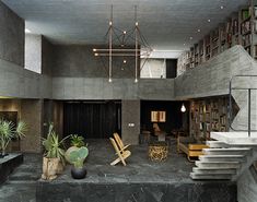 the interior of a modern house with concrete walls and flooring, potted plants on either side of the stairs