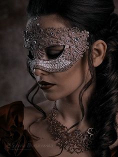 a woman wearing a masquerade and jewelry