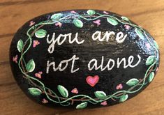 a painted rock that says you are not alone