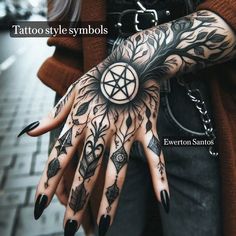 a woman with black nails and tattoos on her hand is holding a pentagramil