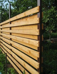 a wooden fence in front of some trees