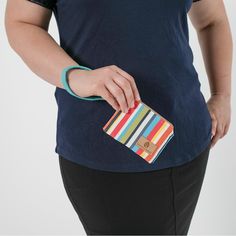 Experience luxury and style with this colorful striped, clip pouch. Its slim design allows for easy pocket access while providing ample space for your ID and cards. Add a touch of sophistication with the removable wristlet strap and carry it solo. Handcrafted by our team of women artisans in recovery, 100% of your purchase goes to provide job skills training and career development for the women who made it. Details 100% upcycled materials Dimensions: 5" x 4" Liner: Upcycled blue fabric Removable wristlet strap Zip closure Silver-tone hardware Handcrafted in NY's Hudson Valley by a woman winning her fight against addiction.#createpossibilities Air Force Uniforms, Theory Of Change, Artisan Bag, Job Skills, Upcycled Materials, Skill Training, Career Development, Shopper Tote, Military Uniform