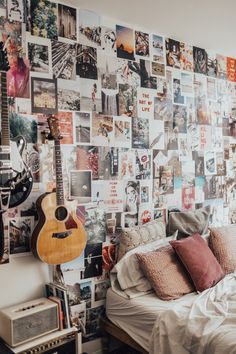 a bedroom with lots of pictures on the wall and a guitar hanging from the ceiling