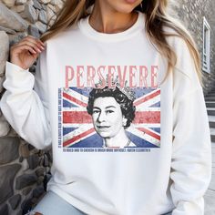 "Make a Bold and Positive statement with our Queen Elizabeth II \"Persevere\" sweatshirt or T-shirt.  This Queen Elizabeth II Sweatshirt (also available on a 100% cotton unisex Tshirt) displays our very own Queen Elizabeth II design created by The Cozy Vibe Shop, which makes it a special addition to your unique taste and royal wardrobe!  To add more than one sweatshirt or tshirt to your cart, choose the size and color then click \"Add to Cart\". Repeat the process for additional items. 💗Availab Crown Queen Elizabeth, Royal Wardrobe, Elizabeth Queen, Crown Queen, Queen Gifts, Queen Shirt, Queen Shirts, 20 Gifts, Unisex Tshirt